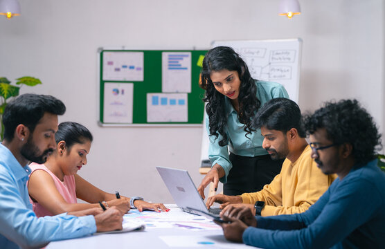 Team of co-workers busy working at office during discussion or business training - concept of communication, startup coordination and woman leadership.