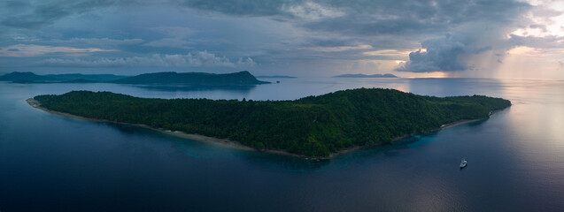 Early morning rain clouds drift near the beautiful island of Ambon, Indonesia. This area is widely...