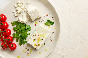 feta cheese, for salads, with cherry , green butter, greens, on a white plate, appetizer, top view, close-up,