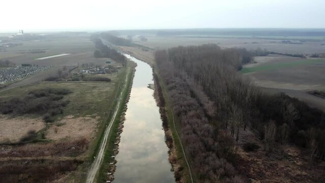 Clouds reflecting of water surface in canal in town Bac, Serbia, aerial view