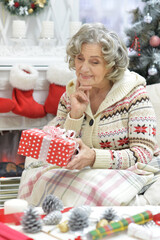 Happy smiling old woman with gift on Christmas
