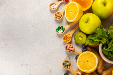 Vitamins and supplements. Variety of vitamin tablets in a wooden spoon on a texture background.Multivitamins with fresh and healthy fruits.Food supplements. Flat lay. Space for text.Copy space