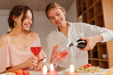 Beautiful happy romantic couple drinking wine, eating food celebration Valentines day or birthday. Smiling elegant man and woman sitting in restaurant. Dating, love, romantic dinner