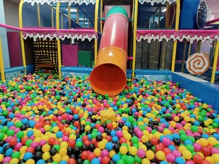 Children's playroom colorful photo, banner. Slide with balls. Cozy play area, copy space. Daycare for toddler. Entertainment center. Labyrinth