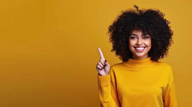 Happy afro woman pointing her finger at copy space for promotion