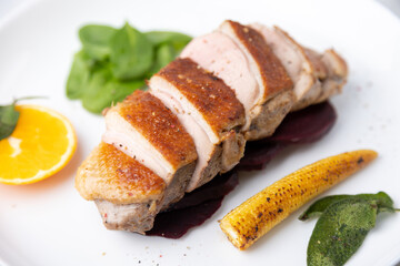 Fillet  of the breast duck grill with beets, mini corn and spinach, fried sage, orange and lingonberry sauce. Traditional Mediterranean cuisine. Selective focus, close-up.