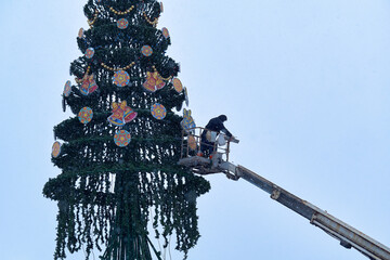 Dismantling the Christmas tree in the city square. The Christmas tree is removed using a vehicle...