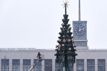 During heavy snowfall, an artificial Christmas tree is installed in the city square. The Christmas...