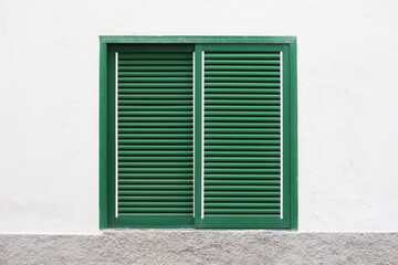 Closed window shutters. Green paint window shutters background.Architecture texture. Object isolated on white house wall facade. Wooden stripes window cover.