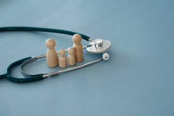 stethoscope and wooden puppets with blue background Health insurance concept Family health care...