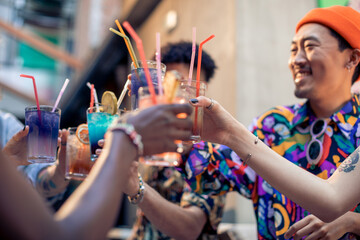 Multiracial group of happy friends drinking cocktails in bar
