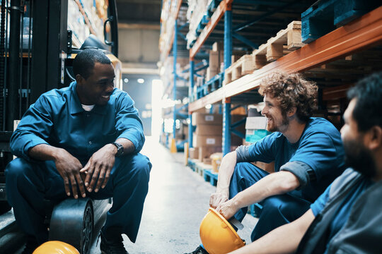 Young men laughing on break from working in warehouse