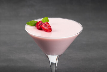 Raspberry cream jelly, Panna Cotta in a martini glass. Dark background. Close up