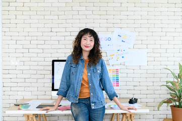 Portrait of cheerful female graphic designers in office. Creative people smiling at the camera during collaborative brainstorming with digital computer posing.