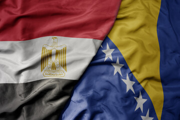 Fototapeta premium big waving national colorful flag of bosnia and herzegovina and national flag of egypt .