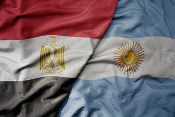 big waving national colorful flag of argentina and national flag of egypt .