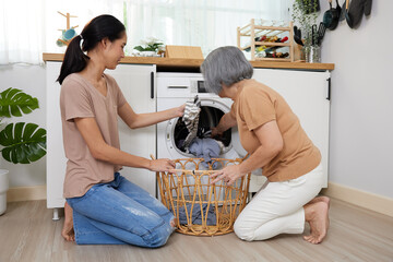 senior woman and young woman doing laundry with washing machine at home