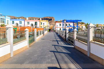 A pedestrian bridge walkway towards the picturesque whitewashed fishing village of Puerto de Mogan...