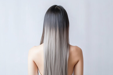 Fototapeta premium The young lady's back, her long silver hair flowing smoothly against the white studio background, showcasing her elegant and chic style. Generative AI.