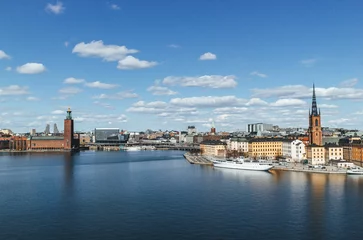 Abwaschbare Fototapete panoramic view of rooftops and view of the town hall tower with many colorful houses in stockholm and water channels huge boat and cloudy sky © Radu