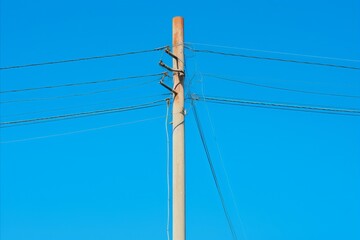Fototapeta premium Bright sparks of electricity surge through interconnected wires against a clear blue sky backdrop