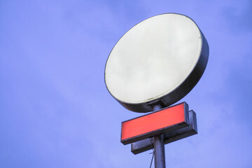 Blank white signboard in circle and rectangle shape at night against blue sky