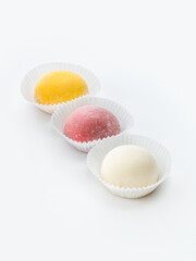 Japanese delicious delicate dessert mochi on a white background in paper forms. Side and top view.