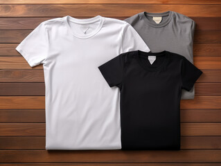 A neat arrangement of folded t-shirts in various colours on a wooden surface.