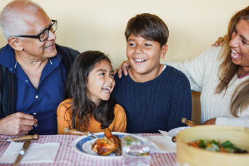 Latin grand parents having fun with grand children after lunch at house patio - Family and love...