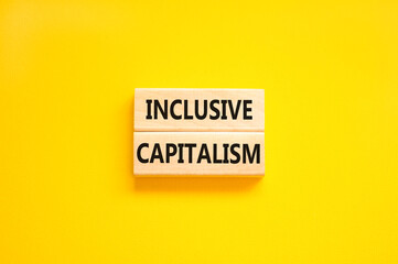 Inclusive capitalism symbol. Concept words Inclusive capitalism on beautiful wooden blocks. Beautiful yellow table yellow background. Business inclusive capitalism concept. Copy space.