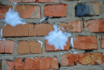 traces of snowballs on a brick wall. throwing snowballs.