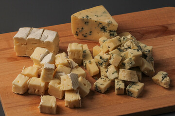 Pieces of cheese assorted on a wooden board