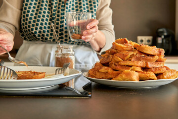 Unrecognizable senior woman spreading panela sugar on the bread for torrijas recipe