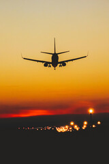 Airplane landing on the runway during sunset and night - 691602989
