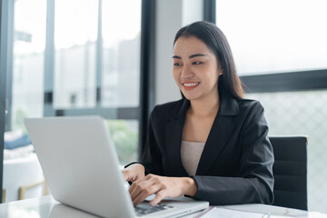 Beautiful confident asian business woman working with laptop Hands typing  keyboard. Professional investor working new start up project. business planning in office. Technology business - obrazy, fototapety, plakaty