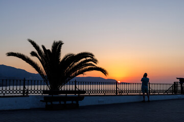 Person enjoying sunrise early in the morning in Nerja, Spain
