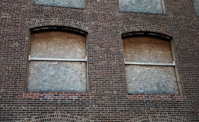 Boarded windows on urban buildings as precaution against riots, symbolizing protection and societal...