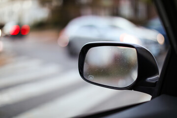 car mirror reflecting cityscape, symbolizing travel, reflection, urban lifestyle, and exploration....
