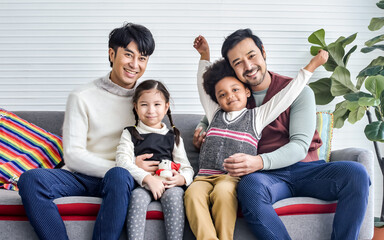 Portrait couple male gay taking care adopted African son, Caucasian daughter with love, looking at...