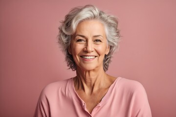 Fototapeta premium Radiant Grace: Happy Senior Woman's Smiling Portrait on Pink Background