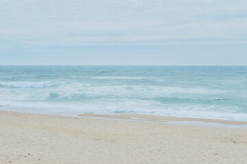 Fototapeta na wymiar ocean waterfront beach on moody windy day in Portugal. Faded peaceful background