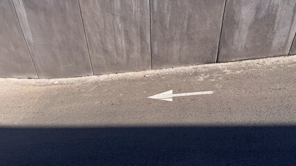 white arrow painted on a street indicating the direction of traffic