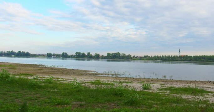 Footage captures the townscape from across the river, standing on beach covered in sand and grass