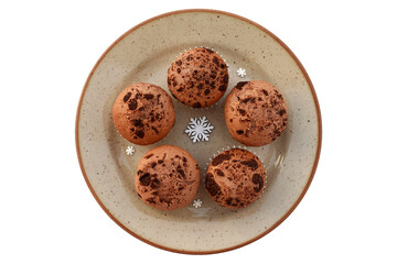 Delicious homemade cocoa muffins with chocolate on a plate, winter decoration around