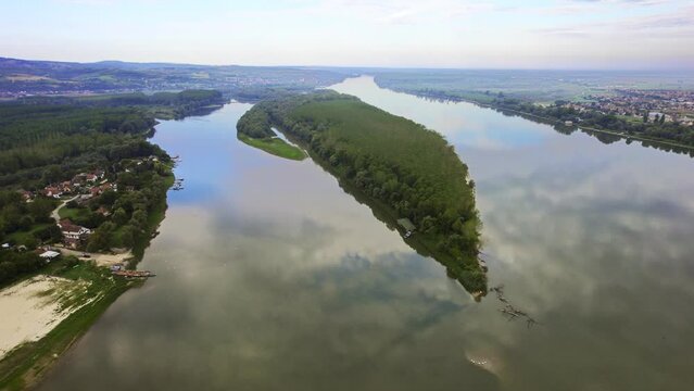 Panoramic aerial footage of river Danube and a wooded island in the middle of it