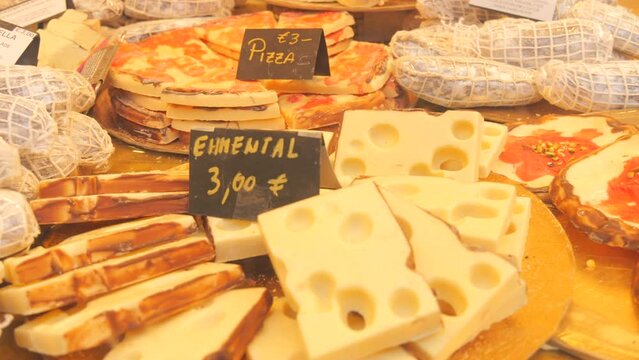 Various chocolate products in the form of cheese, a slice of pizza or bruschetta. Many different chocolates on the counter of the Christmas market. Sign of chocolate names in German. Sweets concept
