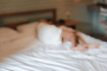 Blurred image of young woman wearing white towel lying on bed in room Victims of human trafficking or prostitution. Concept of against sexual services in tourism. - obrazy, fototapety, plakaty