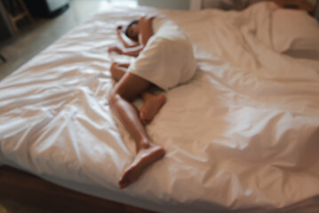 Blurred image of young woman wearing white towel lying on bed in room Victims of human trafficking or prostitution. Concept of against sexual services in tourism.