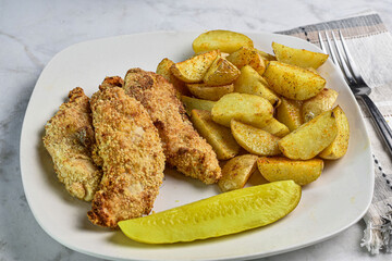 chicken fingersserved with potato wedges and  pickle