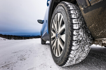 Winter Tires Treads on a SUV on a Road Covered in Snow